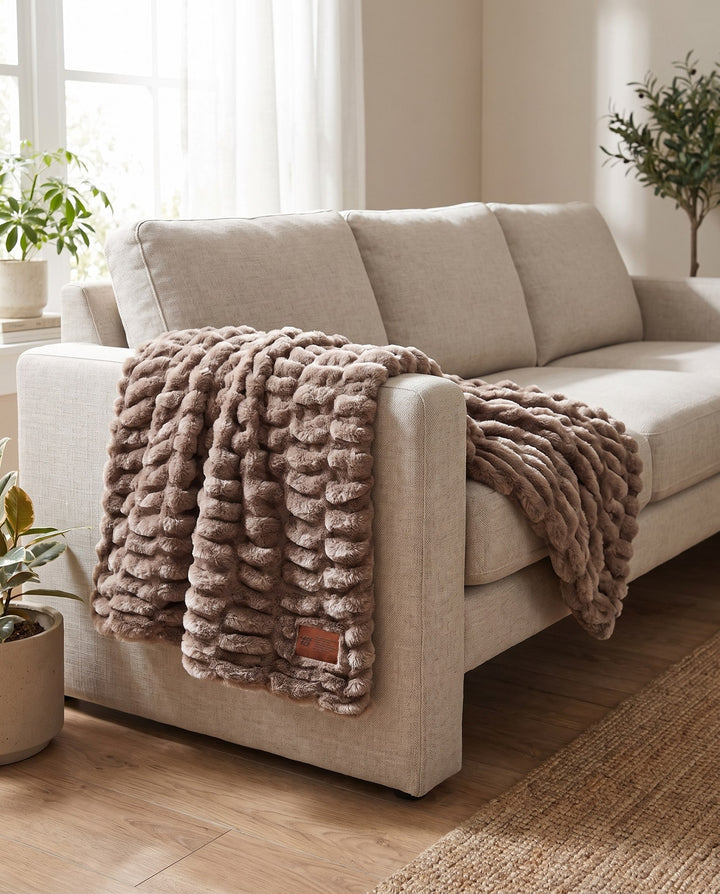 Be Still Blanket draped over the arm of a linen sofa