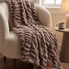 Be Still Blanket draped over a cream boucle armchair