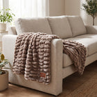 Be Still Blanket draped over the arm of a linen sofa