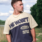 Man wearing Christian streetwear tee with 'He Won't Give Up On Me' text outdoors