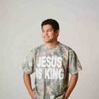 Man wearing camo print Christian t-shirt with bold JESUS IS KING text, casual outfit