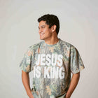 Man wearing camo t-shirt with bold white Jesus Is King text, Christian faith apparel