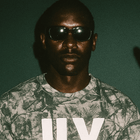 Man in sunglasses wearing green camo heavy tee with large white JLY text graphic