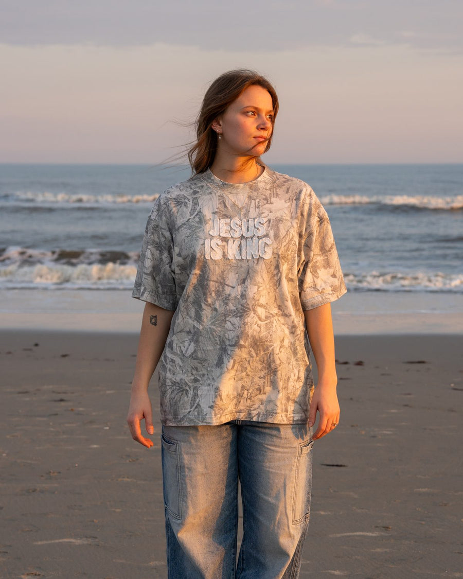 MJ wearing the Jesus Is King camo patchwork tee on the beach