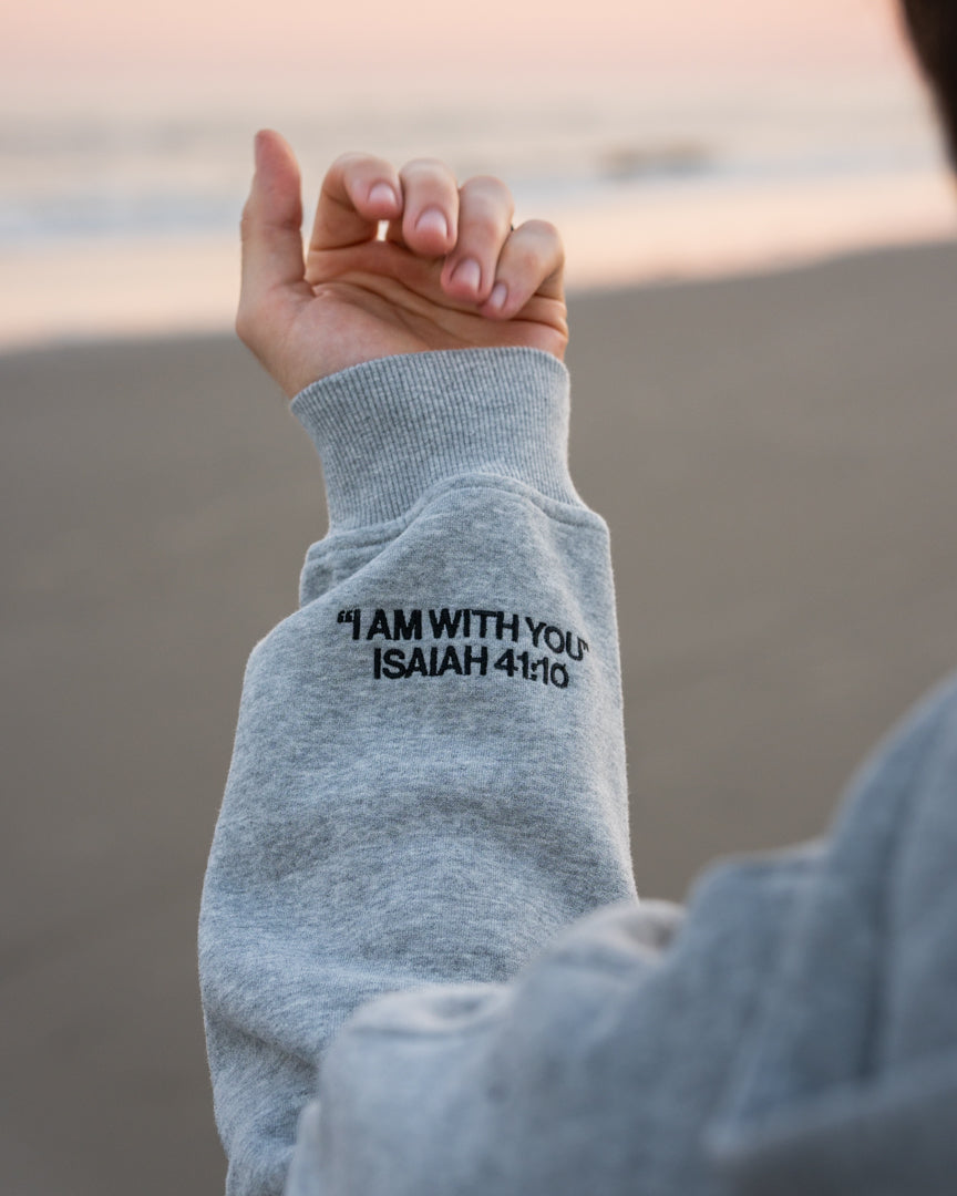 Heather Gray (BE STILL & KNOW): I AM WITH YOU Isaiah 41:10 sleeve embroidery in black, Brett is 6'1" wearing size M