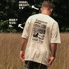 Man in beige 'Tomorrow Needs You' mental health awareness t-shirt standing in field