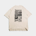 Beige t-shirt with inspirational 'Tomorrow Needs You' text and black floral landscape graphics on back.